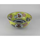A Chinese ceramic fruit bowl with yellow lemon band and circular panels of flowers and patterns,