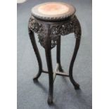 A Chinese carved hardwood jardiniere stand with marble inset top above a carved and pierced