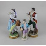 A pair of Dresden porcelain bird seller figures with birds and cages 20cm and another of a