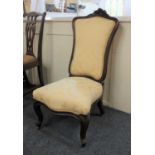 A Victorian upholstered low chair with floral carved cartouche shaped back, yellow damask upholstery
