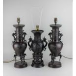 A pair of Japanese bronzed metal two handled vases converted to table lamps, decorated with birds