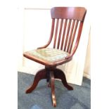 An early 20th century oak office chair with slatted back, on swivel base (a/f)