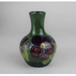 A small Moorcroft pottery 'Clematis' pattern baluster vase 13cm high