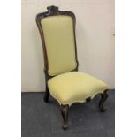 A Victorian carved rosewood framed low chair with upholstered back and seat, on scroll legs