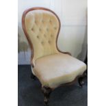 A Victorian balloon back nursing chair with pale gold upholstered button back and seat, on
