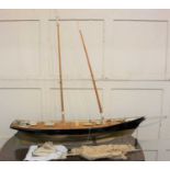 A painted wooden model pond yacht with two detachable masts, 112cm wide, on stand, with sails and