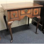 A 19th century oak crossbanded kneehole desk with three drawers on cabiole legs with hoof feet,