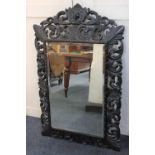 A Flemish style carved oak wall mirror with lion mask surmount and pierced scroll border, ht 116cm