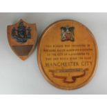An oval wooden plaque inscribed 'This Plaque was Presented by The Lord Mayor Aldermen & Citizens