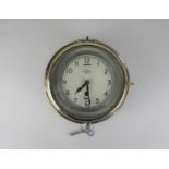 A Mercer brass bulkhead clock 20cm, with key