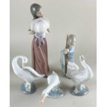 A Lladro porcelain figure of a girl holding a hat 25cm, and another of a figure holding a staff (