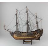 A scratch built wooden model of a three-masted warship 54cm long, on wooden stand (a/f)