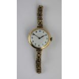 A 9ct gold circular cased ladies wristwatch, the jewelled lever movement detailed 'BIRD IN RING',