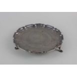 An Elizabeth II silver circular card tray with pie crust border on three hoof feet, maker Mappin and