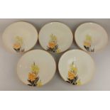Five Susie Cooper porcelain plates with yellow and orange floral decoration 23cm