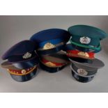A collection of replica military hats to include East German Army guard, and Soviet Air Force