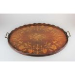 An Edwardian marquetry inlaid oval tray decorated with scrolling flowers, two brass carry handles,