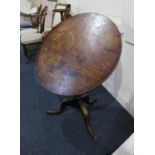 A George III mahogany circular tilt top tripod table on baluster support, 70cm