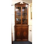 An Edwardian Sheraton style inlaid mahogany corner cupboard the top with broken arch cornice, two