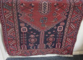 Three Persian rugs including a crimson ground rug with lozenge design, (a/f) 176cm by 97cm