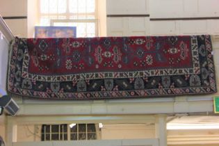 A Persian type rug, red ground, with geometric motifs within a multiguard border, approx 277cm by