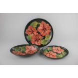 A Moorcroft pottery pink Hibiscus pattern oval bowl 23cm, oval dish 23cm, and plate 25.5cm