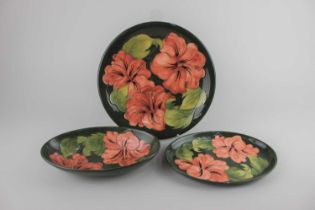 A Moorcroft pottery pink Hibiscus pattern oval bowl 23cm, oval dish 23cm, and plate 25.5cm