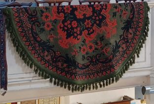 A green circular rug with red and black floral decoration approx 194cm