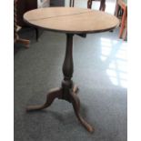 A 19th century oak occasional table with circular tilt-top on pedestal stem to outswept tripod