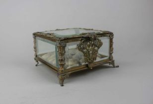 A gilt metal jewellery casket with bevelled glass panels and padded interior, raised on four hoof