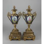 A pair of Sevres style gilt metal and porcelain garniture vases, each decorated with an oval panel