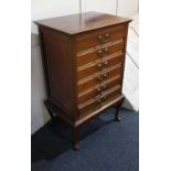 A mahogany music cabinet six drawers with fold down fronts and brass drop handles, on cabriole legs,