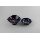 Two Moorcroft pottery Orchid pattern bowls, blue ground, largest 14cm diameter