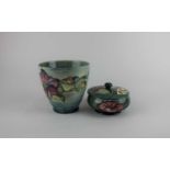 A Moorcroft pottery Hibiscus pattern pot and cover 11.5cm diameter, together with a Moorcroft