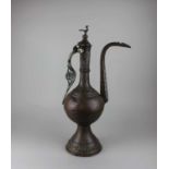 A large Eastern brass flagon, the lid with bird shaped finial 62.5cm high