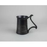 A studio pottery mug black pewter effect glaze with scroll handle, indistinct stamped mark to