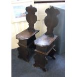 Two Italian Florentine hall chairs with solid seats and shaped backs and supports