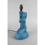 A figural blue ceramic table lamp in the form of a kneeling figure 33cm high including fitting