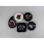 A collection of five Moorcroft pottery ashtrays, to include Columbine and Clematis pattern (a/f)
