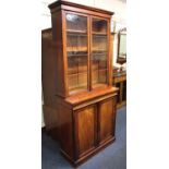 A Victorian mahogany bookcase cabinet with two glazed panel doors enclosing three shelves, above two