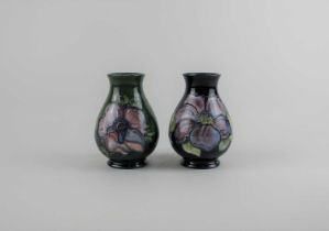 Two small Moorcroft pottery vases in Clematis pattern on blue ground 10cm, and Anemone pattern on