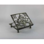 A brass missal stand with pierced decoration and central letters 'IHS' 27.4cm by 24cm