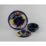 A Moorcroft pottery Anemone pattern bowl, a Wisteria pattern plate, and a Hibiscus pattern oval