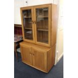 An Ercol dresser top section with two glazed doors on base with two cupboards, on castors, 92cm