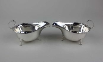 A pair of George V silver sauce boats, each with flying scroll handle on three pad feet, maker