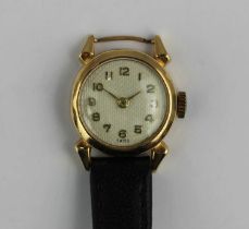 A gold circular cased lady's wristwatch the silvered dial with gilt Arabic numerals and with gilt