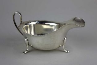 A George VI silver sauce boat with scallop edged rim on three feet, maker Viner's Ltd Sheffield 1940