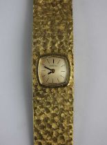 A Certina gold ladies bracelet wristwatch, rear winding the curved champagne coloured dial with