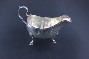 An Irish George III silver sauce boat with scroll handle, fluted and punched line decoration on