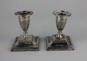 A pair of Victorian Neo-Classical silver dwarf candlesticks with vase shaped sconces on stepped